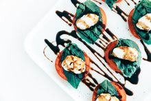 Load image into Gallery viewer, caprese: mozarella balls on tomato slice with basil and balsamic drizzle
